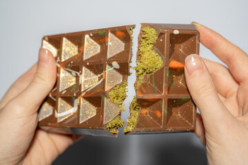 Close up of famous Dubai chocolate with pistachio, tahini and kadaif broken in woman's hands....