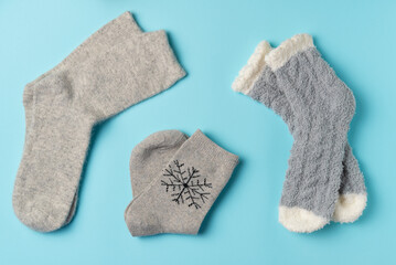 Different winter socks on blue background. Flat lay, top view