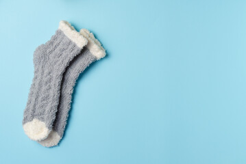 Pair of warm gray socks on a blue background. Flat lay, top view. Copy space