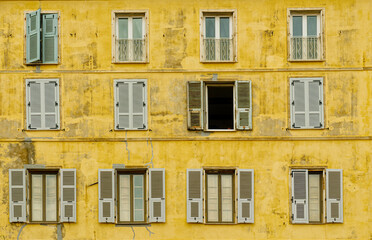 Obraz premium Green Shutters on Old Yellow Building