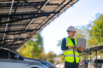 Engineer in safety vest and helmet pointing towards a solar powered carport, illustrating eco-friendly innovation in parking infrastructure. Solar panels provide shade and sustainable energy.