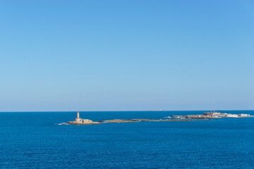 Fototapeta premium Lighthouse at isola Traversa at the entrance of the port on a beautiful sunny day, Brindisi, Puglia, Italy