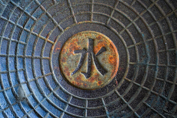 Fototapeta premium Water characters on the metal manhole cover of Suzhou street in the summer palace, Beijing