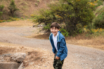 niño jugando y viviendo aventuras en la montaña
