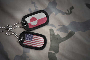 army blank, dog tag with national flag of greenland and united states of america on the khaki texture background. military concept. © luzitanija