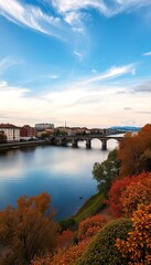 Autumnal River Scene with Stone Bridge and City Buildings