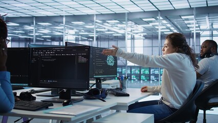 Angry woman getting computer crash while trying to fix error in high tech data center. Furious employee in server farm struggling to repair bugs in mainframes, arguing with colleagues, camera B