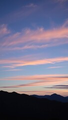 Obraz premium Pink Sunset Hues Over Silhouetted Mountain Range