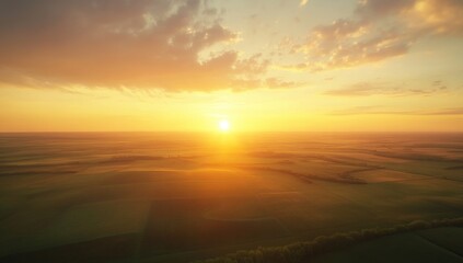 Obraz premium Golden Sunset Over Rolling Fields: Aerial View of Serene Landscape with Warm Colors, Dramatic Sky and Peaceful Atmosphere at Dusk