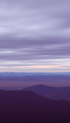 Obraz premium Serene Purple Hues Across Distant Mountain Ranges