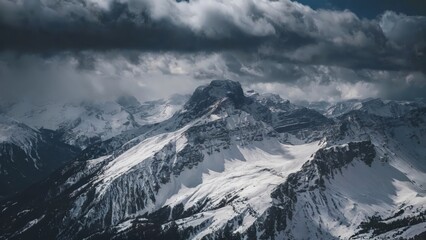 Obraz premium Harsh Aerial Perspective of the Alps, Austria Aerial view of the Austrian Alps under dark, stormy clouds, with rugged
