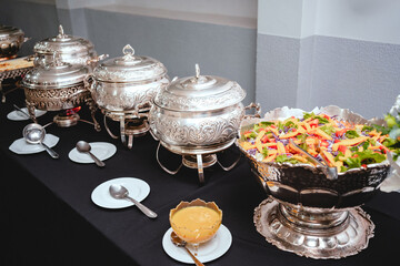 a buffet table with silver plates with food