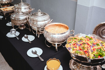 a buffet table with silver plates with food