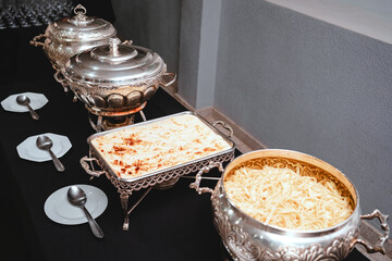 a buffet table with silver plates with food
