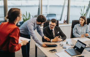 Multicultural business people engaged in a meeting around a conference table in a modern office....