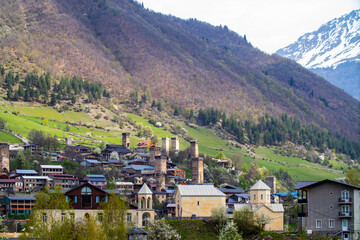 Behind a city Mestia, there is a mountain and Svanetian towers.