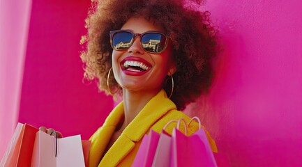 Fototapeta premium A beautiful woman with curly hair and sunglasses is smiling while holding shopping bags against a red background