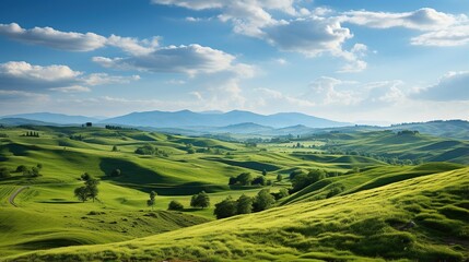 Obraz premium Serene Green Hills Under a Blue Sky with Soft Clouds and Mountains