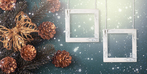 Christmas background with two empty picture frames mockup, decorative fir tree branch, bow and cones for decoration. New Year winter holidays concept with decor and copy space, snowy top view banner.