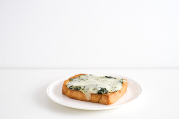 Spinach and cheese bread on a white plate.