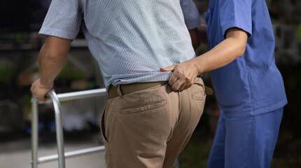 Caregiver holding gait belt for help support patient stand and walk in home.