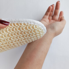 A woman washes herself with a washcloth. Linen washcloth made of natural materials. A sponge for washing the skin. 