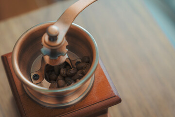 Vintage Coffee Grinder with Beans on Wooden Surface