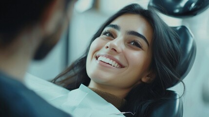 A joyful patient rests in the dental chair, radiating happiness during her appointment, engaging with the dentist in a friendly atmosphere that eases her nerves