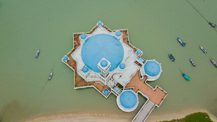 Aerial drone view of a floating mosque  by the seaside at Tanjung Bungah, Penang, Malaysia 