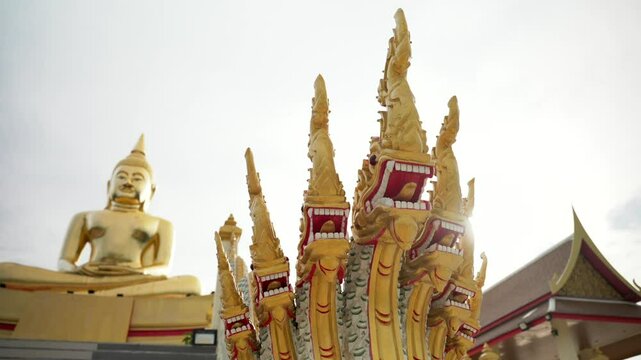 Seven heads Naga dragon statue protects Big Golden Buddha sitting in meditation lotus position. Luang Pho Sothon Temple, Hua Hin, Thailand