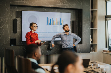 A confident business team presents financial data in a modern conference room. The scene depicts a multicultural group of business people engaging in a professional presentation with charts and graphs