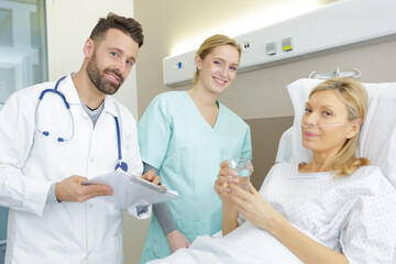 Fototapeta premium doctor sitting assisting senior female patient on bed
