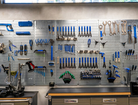Pegboard with various tools hanging in bicycle repair shop