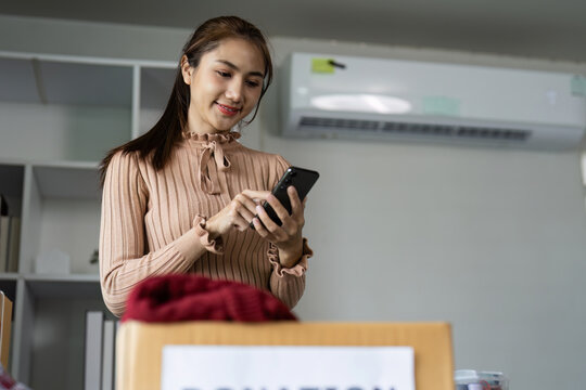 Young Woman Organizing Clothing Donations in Modern Office with Recycling Symbol on Box - Powered by Adobe