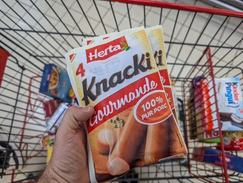 France, 12 August 2024 : Shopping cart filled with Knacki sausages and assorted groceries