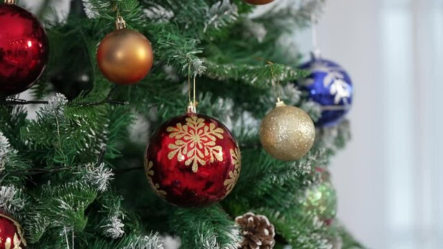 Woman's hand with a Christmas tree ball. Choosing decorations for the New Year tree. Women's preparation of the house for the celebration of the holiday. 