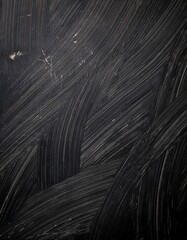 Obraz premium Close-up texture of a scratched black surface with curved abrasion lines and scuff marks, dark grunge background, rough and worn look, high detail, moody lighting.