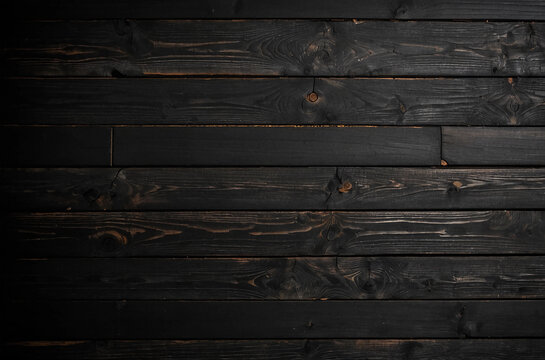A black wooden background with a few brown spots