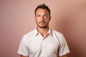 Fototapeta premium A man in a pink shirt is standing in front of a pink wall