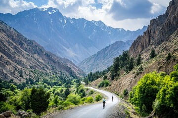 Fototapeta premium Cyclists Riding on Scenic Mountain Road in Lush Green Valley