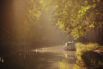 A boat parked on the river in the morning sunlight in France, Europe