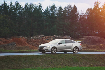 Sedan passing by industrial zone road