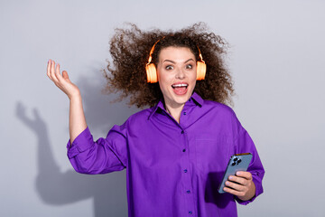 Photo of nice young woman throw hair phone headphones wear purple shirt isolated on grey color...
