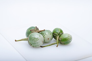 Healthy green round mini eggplant vegetable photographed with white base and background