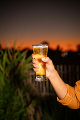 Young beer man holding a glass of beer in his hand, drinking craft beer to test the taste and color of beer in a craft brewery.
