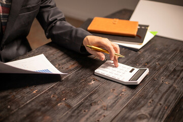 A man works overtime at his desk in the office of the office to clear documents to send to the...