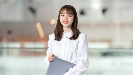 パソコンを持つ笑顔の女性・ビジネスウーマン