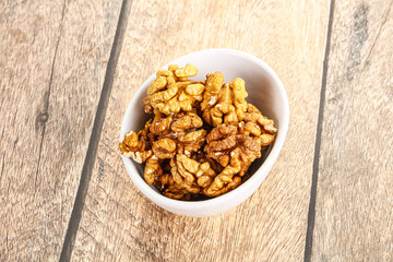 Cracked unshelled walnut in the bowl