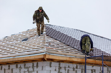 A man is on a roof, working on a roof