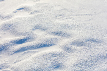 A snow covered ground with a few footprints